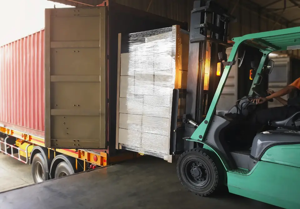 Gabelstapler lädt eine Palette mit Kartons in einen Container auf dem Lkw